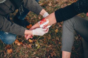 EHBO cursist oefent het verbinden van een wond op de arm van een andere man